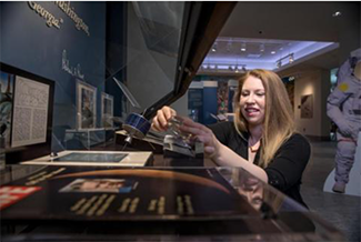 History graduate student Sarah Anderson with the “Moon Rock” NASA installation at the Special Collections Library