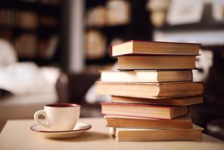 A stack of books with a coffee cup.