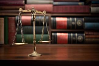 photo of a set of metal scales symbolizing justice on a table in a library