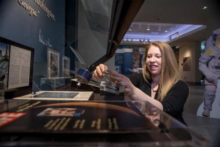 Photo of Sarah Anderson working on The Moon Rocks! exhibit at Russell Library