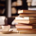 A stack of books with a coffee mug.